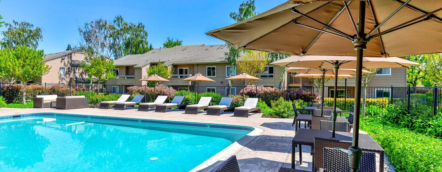 a pool with a patio and umbrella